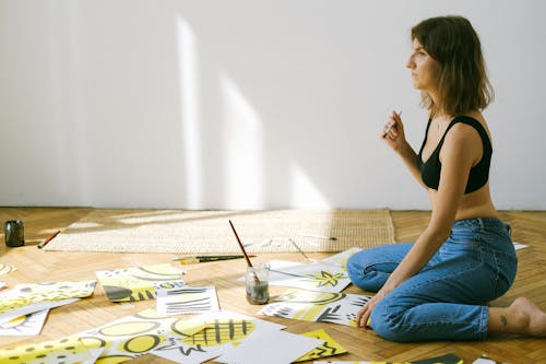Photo of Woman Sitting on Floor While Painting