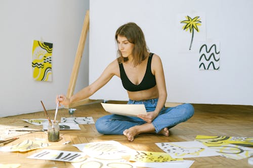 Photo of Woman Sitting on Floor While Painting