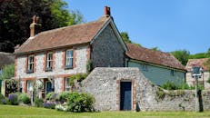 这座美丽的乡村住宅拥有石制立面，花园在蓝天下郁郁葱葱