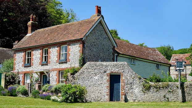 这座美丽的乡村住宅拥有石制立面，花园在蓝天下郁郁葱葱