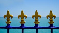 金色和蓝色金属围栏装饰着海景，尽显宁静与优雅