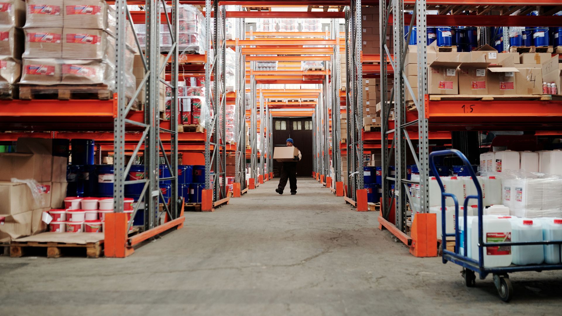 Warehouse aisle with pallet racking and worker