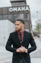 自信的人在奥马哈标志的背景下，身着黑色西装，捕捉商业城市的氛围