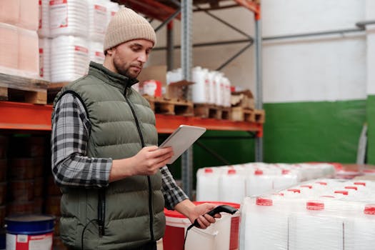 Man managing inventory with tablet in warehouse, focusing on efficiency in storage operations.