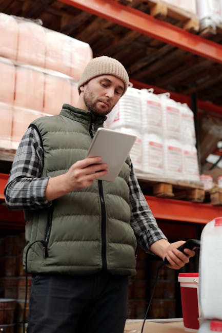 A worker reviewing a customized PDF compliance form on a tablet in a warehouse. A moment pictured by Tiger Lily