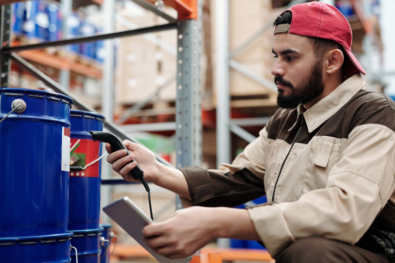 Inspector with clipboard checking packed carton boxes in a warehouse during a pre-shipment inspection