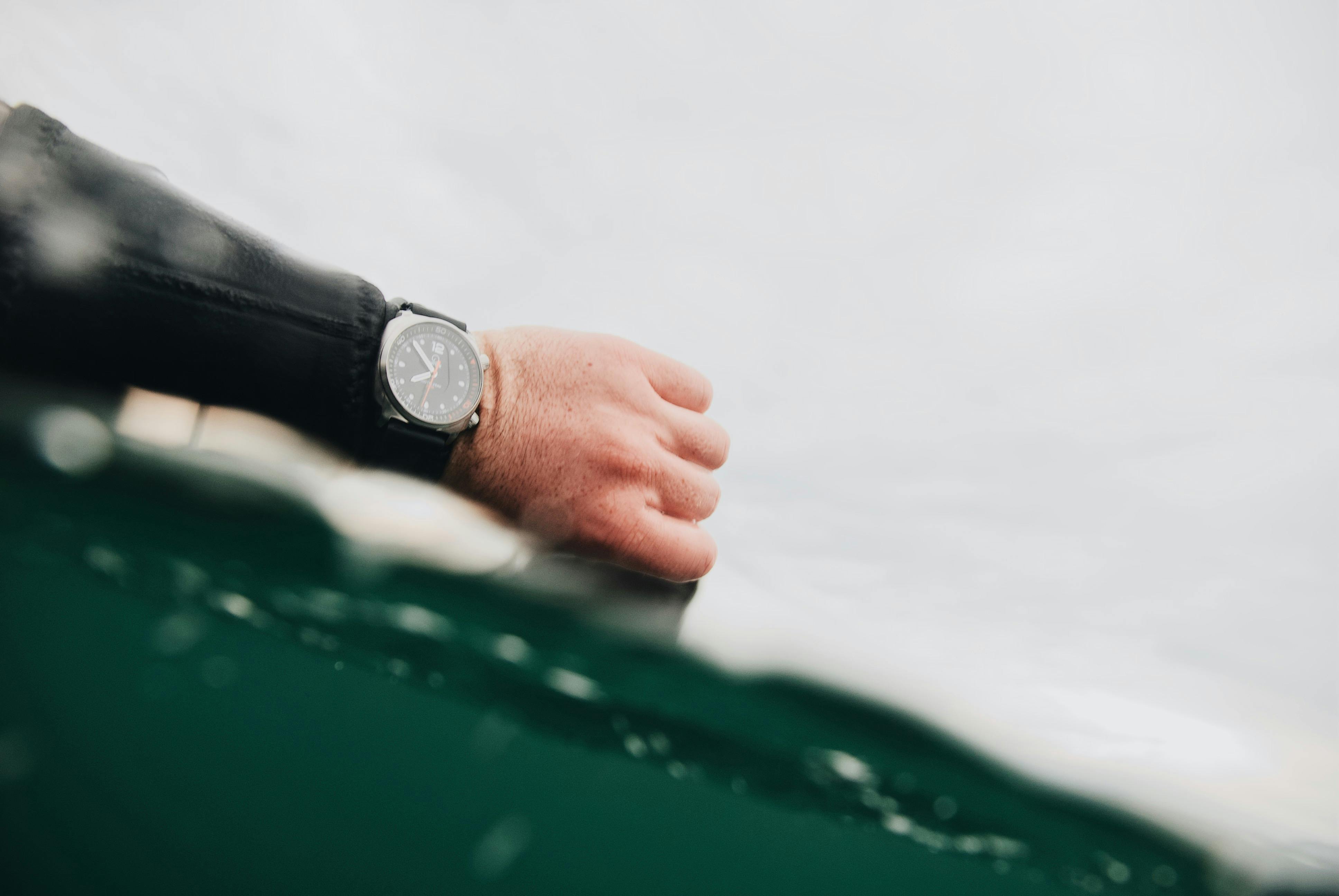 person wearing silver round analog watch