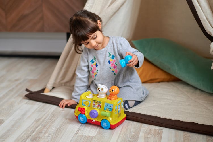 Photo Of Girl Playing With Plastic Toy Car