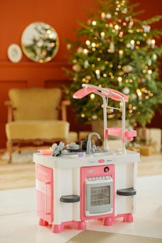 A brightly colored kids kitchen toy set in a festive room with a Christmas tree.