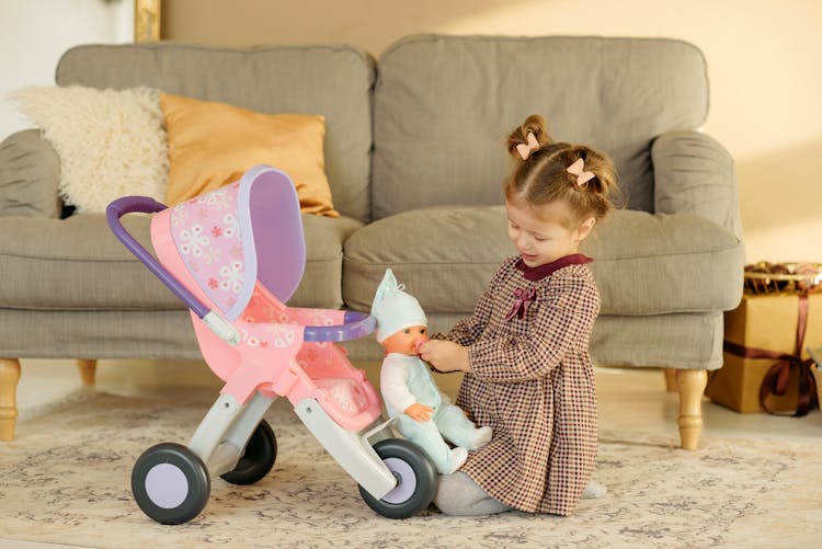 Girl In Plaid Dress Playing With Baby Doll