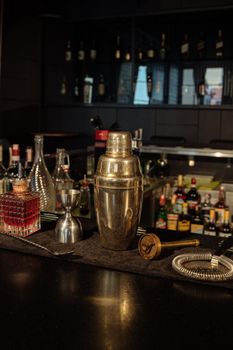 酒吧柜台设备齐全，配有经典鸡尾酒调酒器和各类烈酒