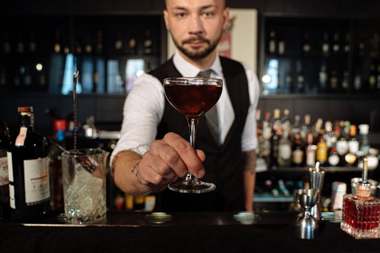 A Man In Black Vest Holding A Wine Glass