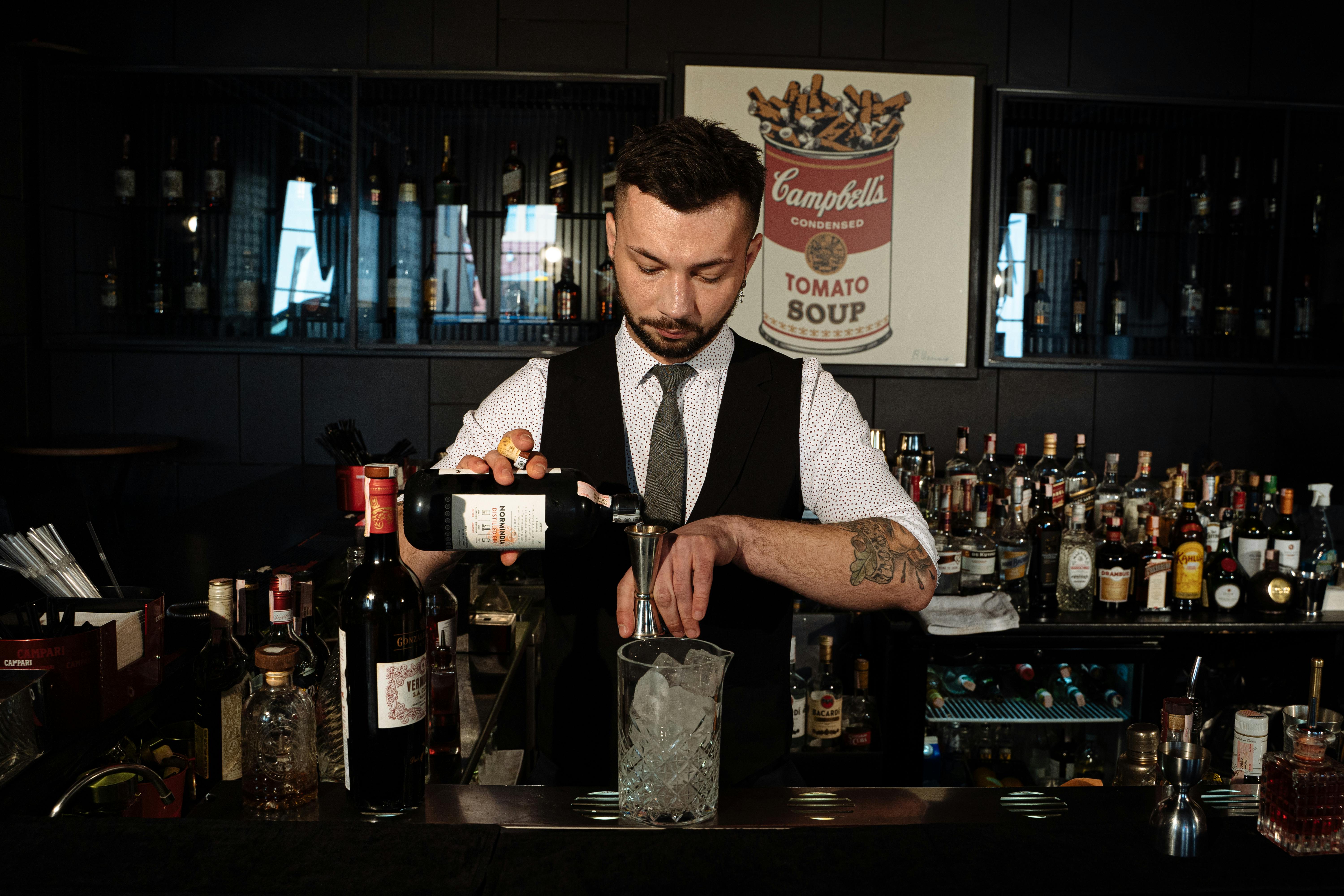 A Man Pouring Wine in a Measuring Cup