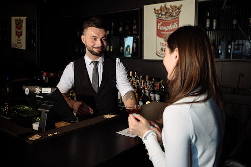 Bartender Serving a Woman at a Bar