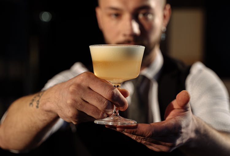 A Bartender Holding A Cocktail Drink 