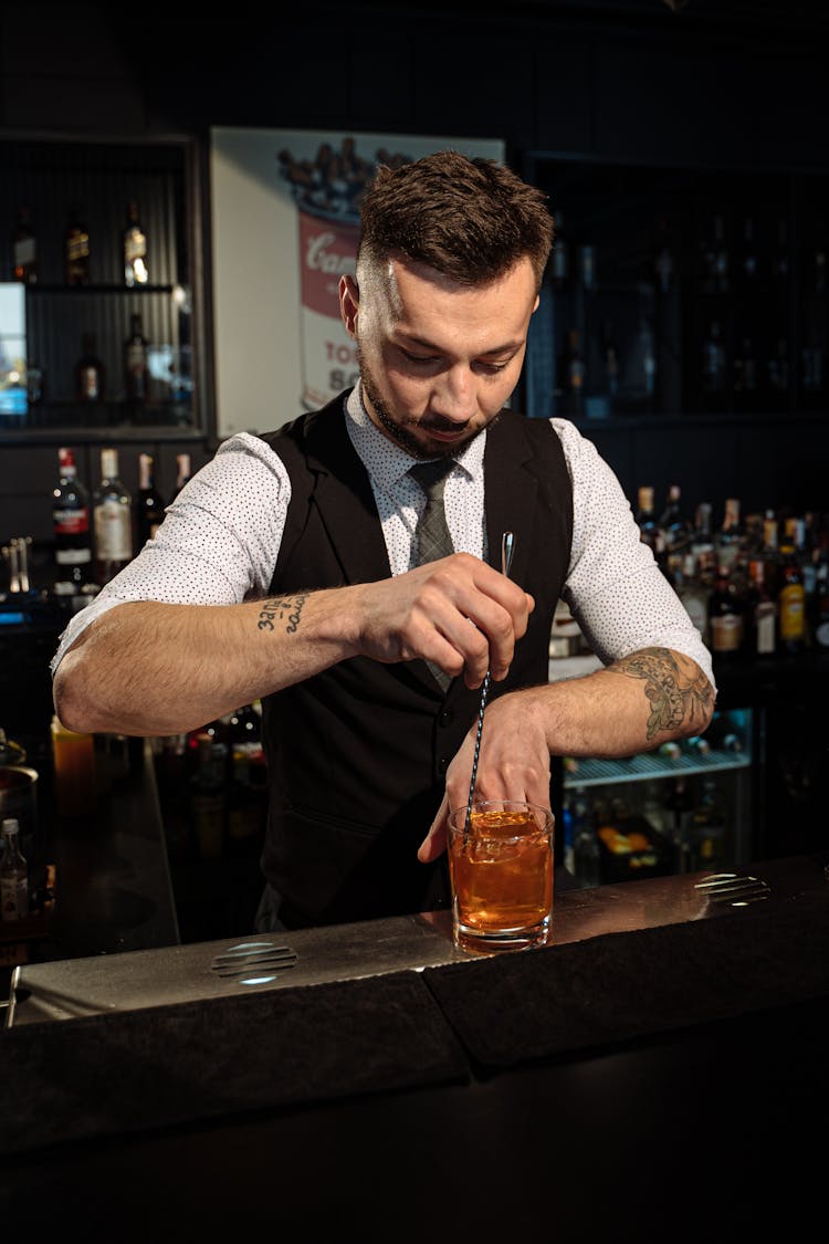 Barman In Black Vest Making Cocktail