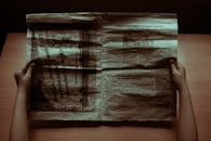 Hands Holding a Vintage Newspaper