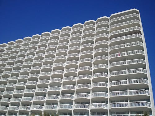 Белое здание кондоминиума под голубым небом