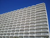 一栋现代化的高层公寓楼，多个阳台映衬着蔚蓝的天空