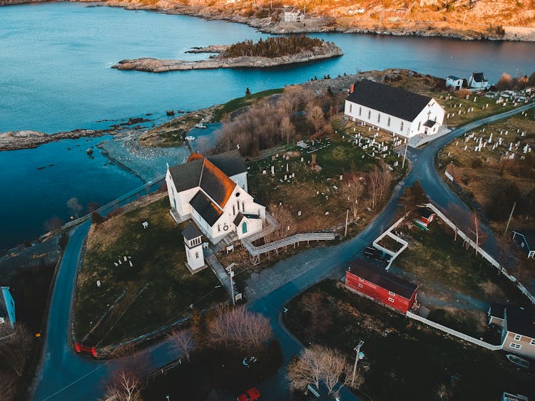 Old Church And Buildings On Hill Near Cemetery And River