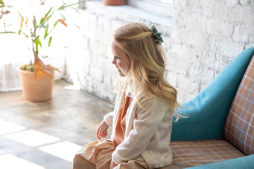 Free Little Girl with Blond Hair Sitting on Chair Stock Photo