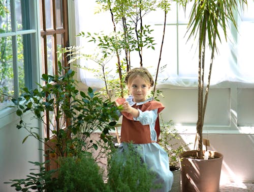 Photo of a Girl Touching a Plant