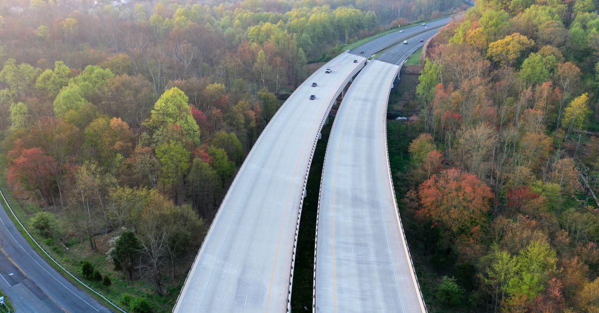 Aerial view of a highway cutting through forested area in Silver Spring during fall.