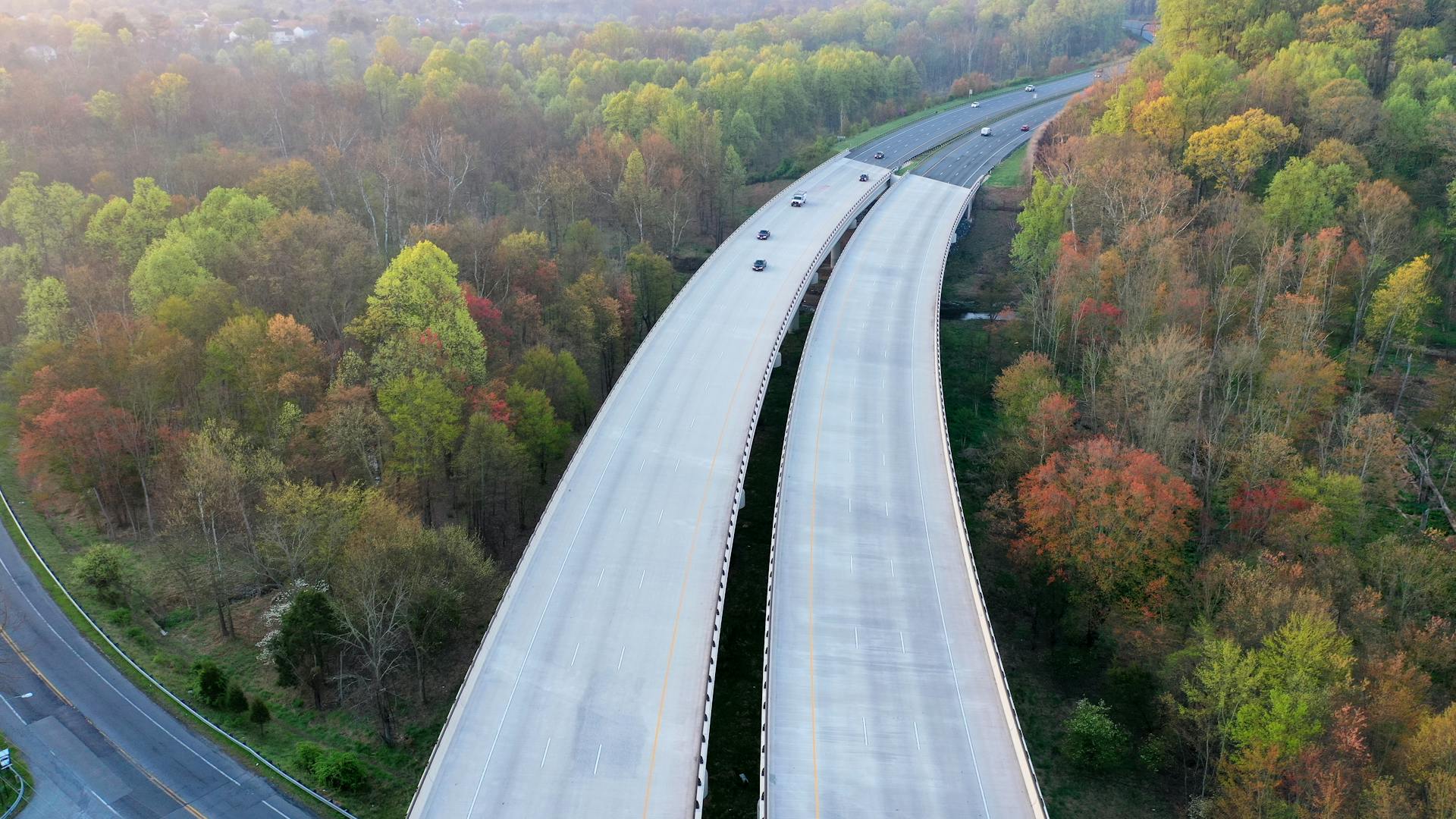 Aerial view of a highway cutting through forested area in Silver Spring during fall.