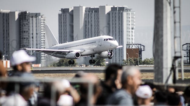 Airplane landing at a crowded Istanbul airport with cityscape backdrop.