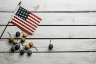 Top view of national USA flag near small tropical fruits on wooden surface