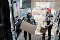 Man in Black Jacket Holding Brown Cardboard Box