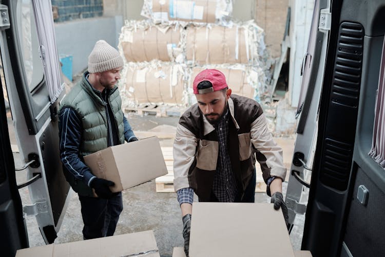 Men Unloading Boxes From The Back Of A Van