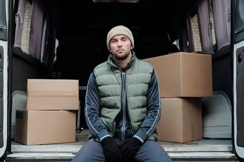 Deliveryman Sitting in a Van with Parcels