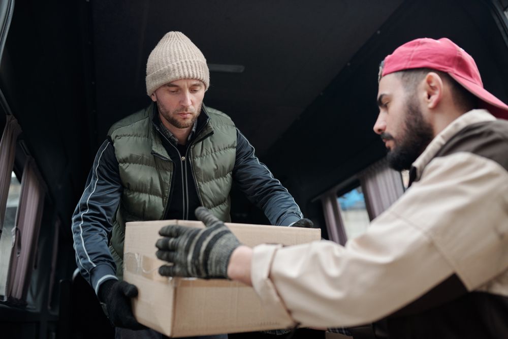 Remise d’un carton près d’un fourgon de livraison