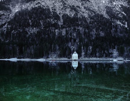 A picturesque alpine house reflecting in a tranquil mountain lake in Breitenwang, Austria.