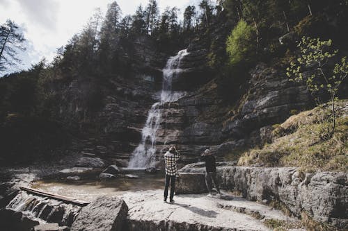 Two Man Taking Photo of Waterfalls