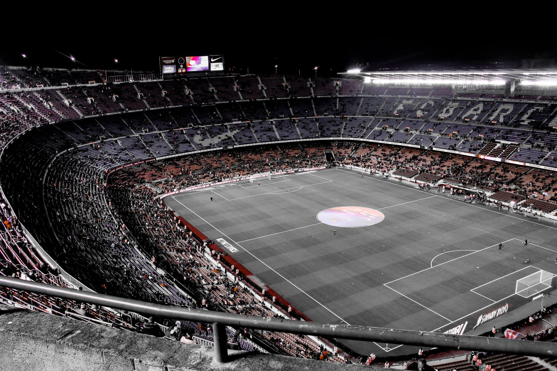 From above of large contemporary soccer stadium with fans on stands and green field