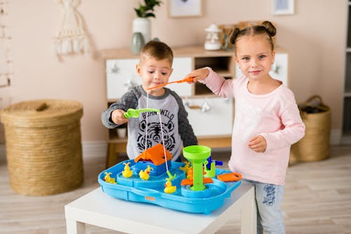 A Young Boy and Girl Playing Toys