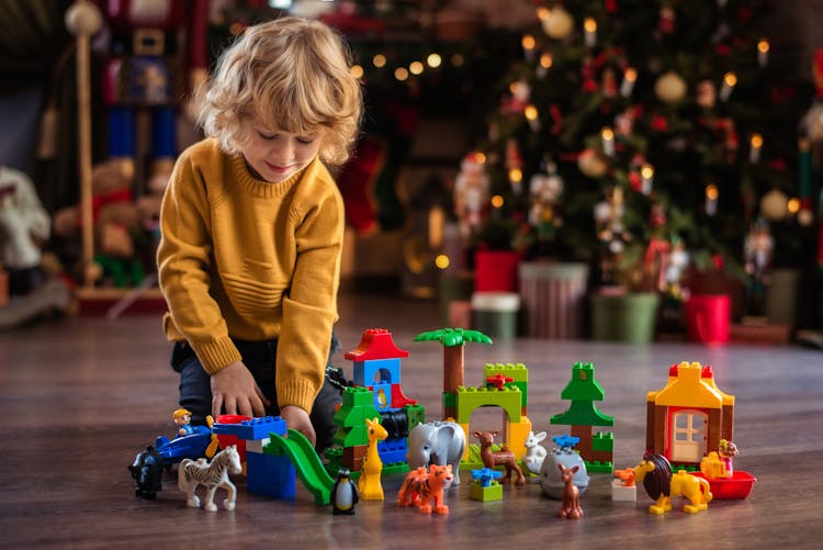 Boy In A Yellow Sweater Playing With Building Blocks