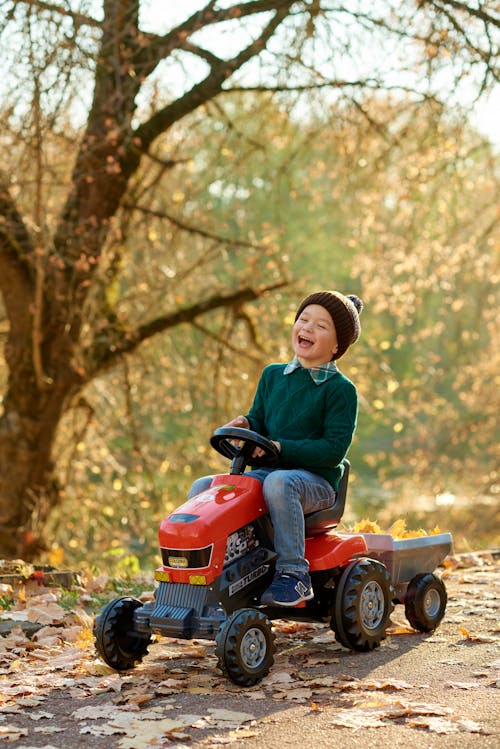 Free Smiling Boy Riding a Toy Truck Stock Photo