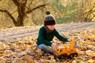 Boy in Green Hoodie Playing With Yellow Toy Truck