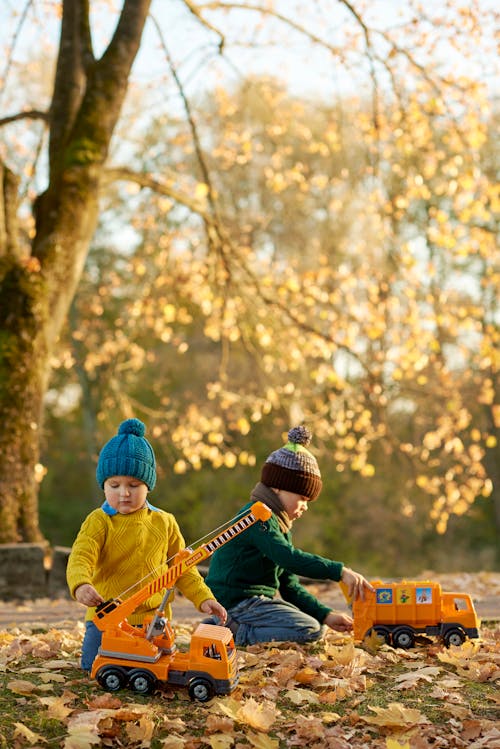 Free Kids Playing with Plastic Toy Trucks Stock Photo