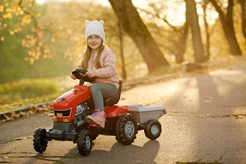 Free Girl Riding a Plastic Tractor Stock Photo