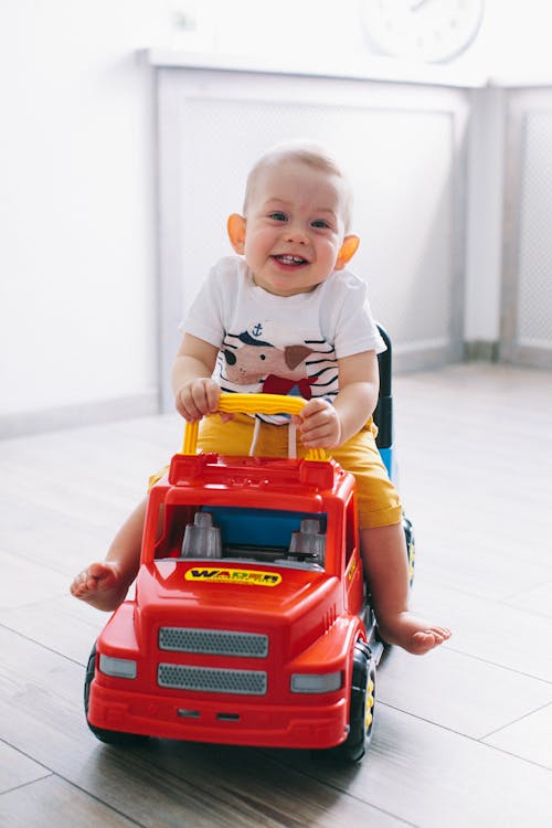 Smiling Little Boy Driving His Toy Car