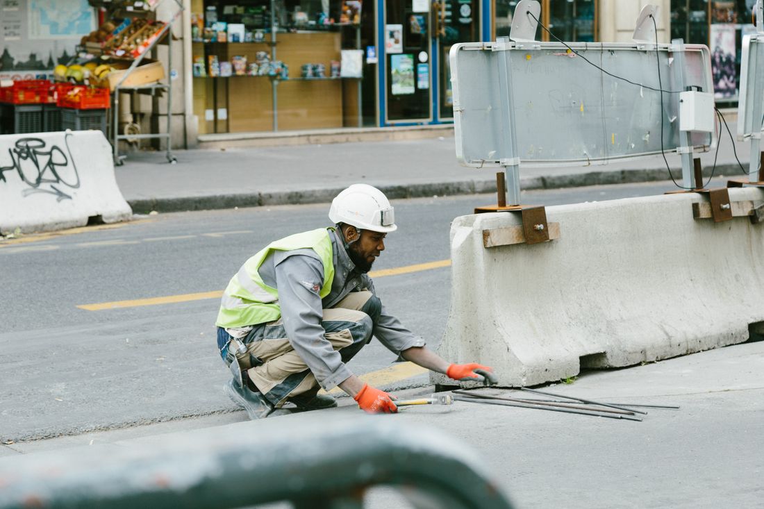 Worker performing asphalt repair on the road