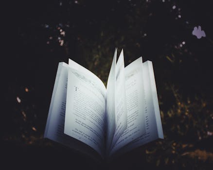 An open book with pages turning, captured outdoors, creating a dreamy reading atmosphere.