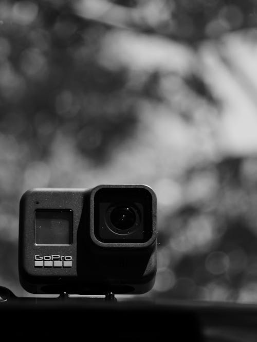 Modern action camera with lens on blurred background