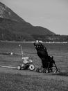 Baby carriage and bicycle on shore near lake and mountains