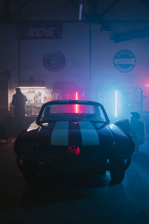 Free A classic car in a neon-lit garage, exuding a cool automotive vibe. Stock Photo