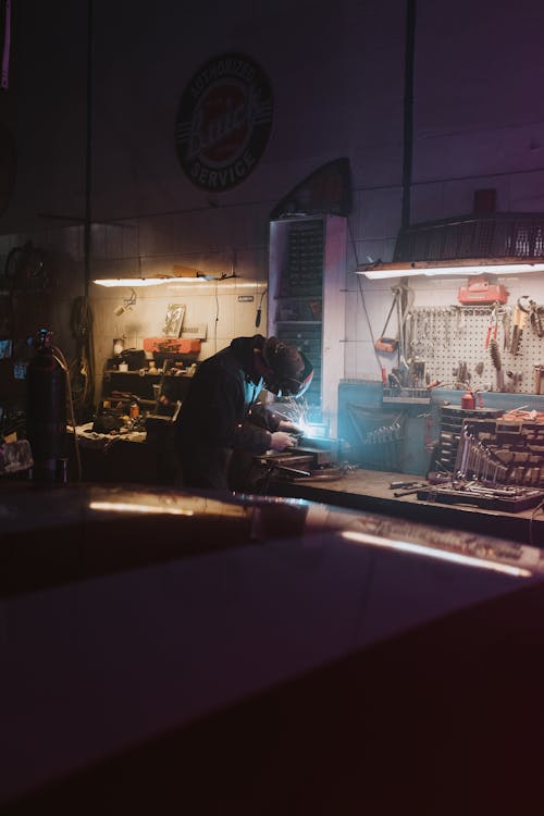 Man in Black Jacket Standing in Front of Counter